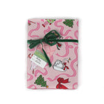 Pink Christmas wrapping paper featuring nutcracker and ribbon motifs.