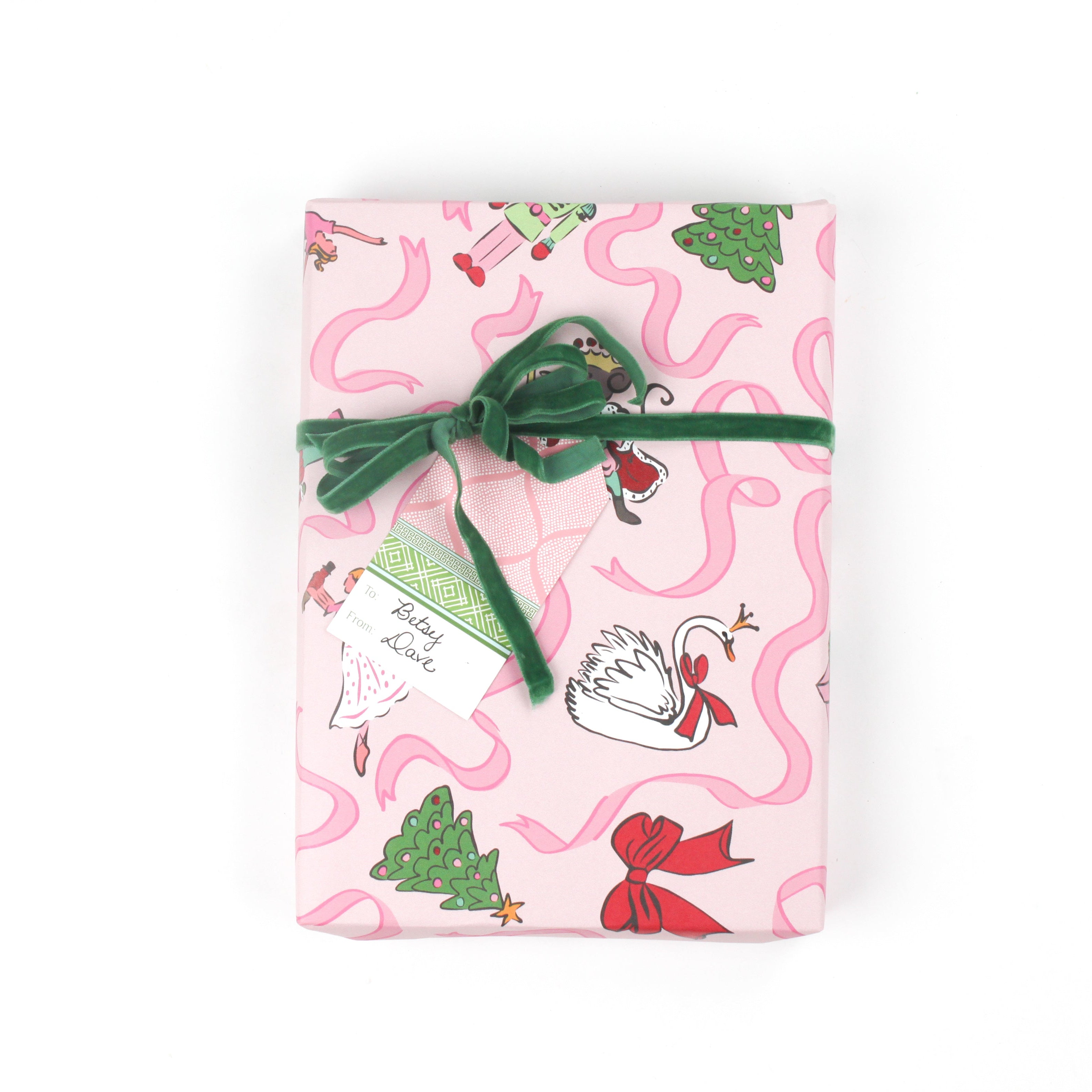 Gift wrapped in pink nutcracker Christmas paper with green velvet ribbon and matching gift tag.