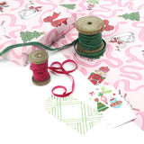 Pink nutcracker Christmas wrapping paper displayed with green and pink velvet ribbons and holiday gift tags.