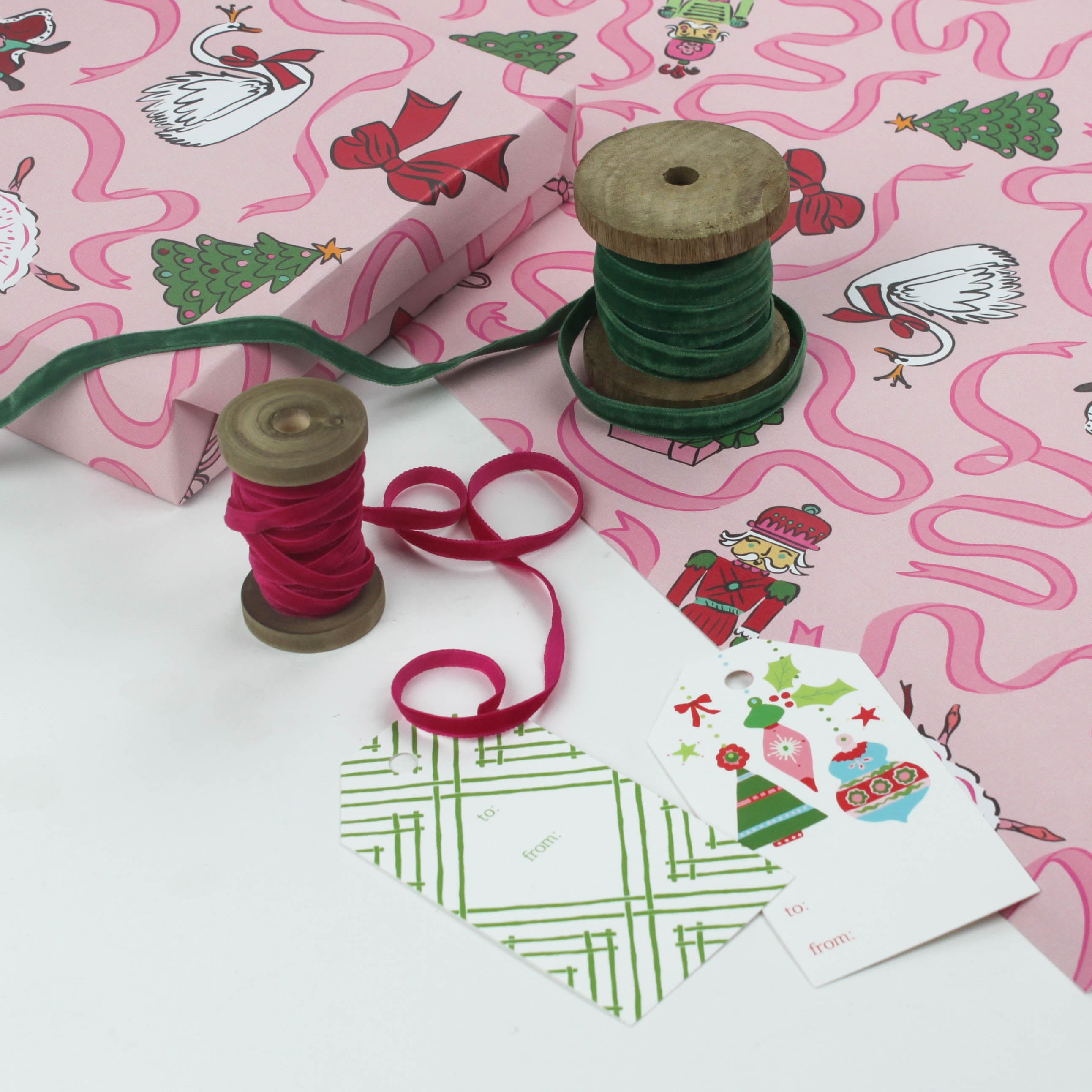 Pink Christmas wrapping paper featuring nutcracker and ribbon motifs.