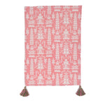 a pink chinoiserie tea towel with white pagodas and green and pink tassels in the corner resting on a white background. 