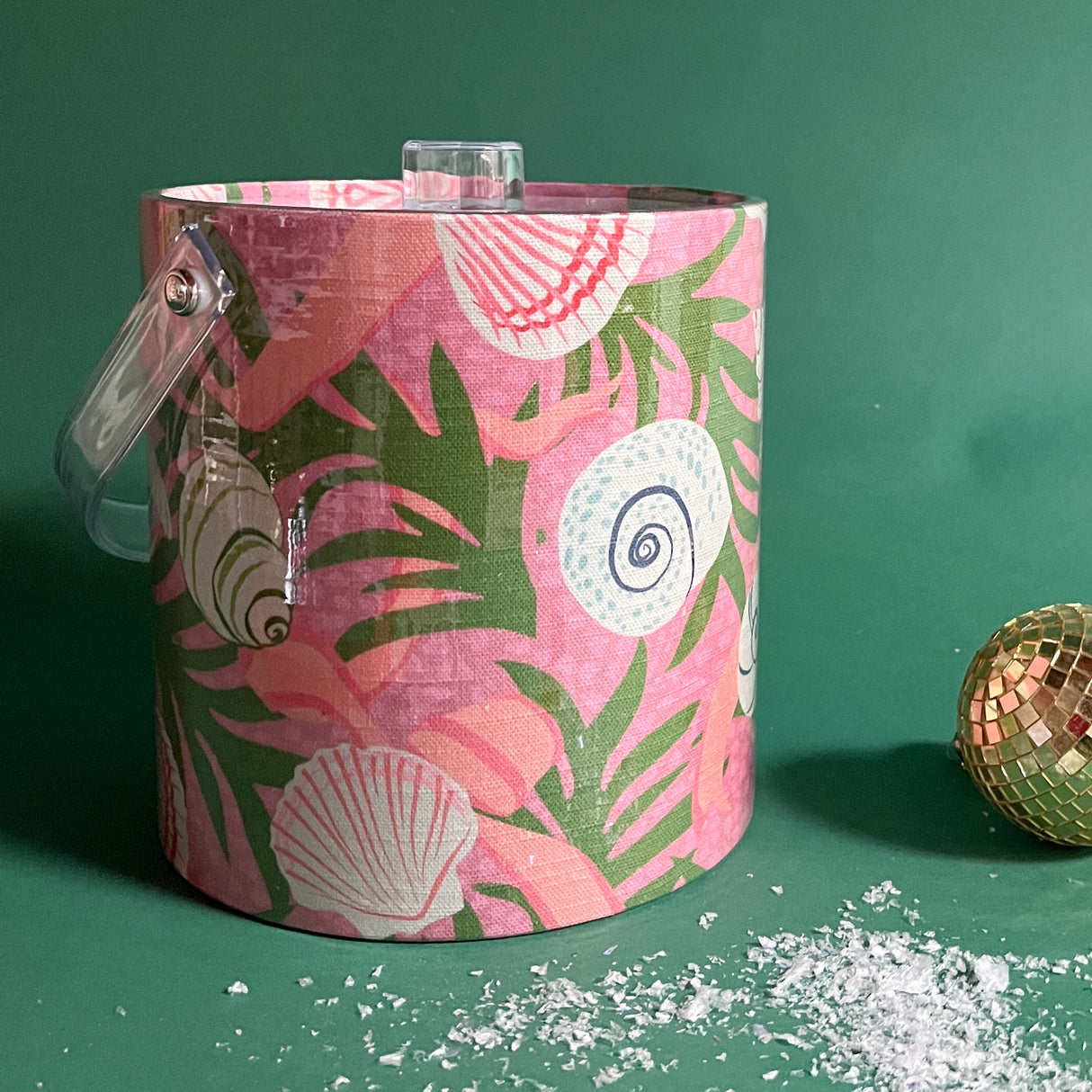 A pink ice bucket with a printed shell and leaf motif all over it. 