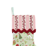 A green Christmas stocking with pug motifs and a pink striped top