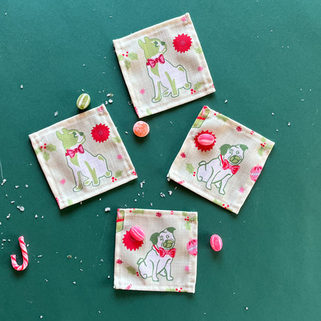 Pug Perfection Christmas cloth cocktail napkins on a green background, featuring a pug and boston terrier dog.