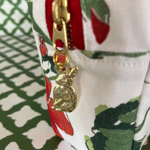 Pull detail of Cottage Grove Geranium is a floral toiletries bag with a red, green, and white color scheme, featuring a geranium design.