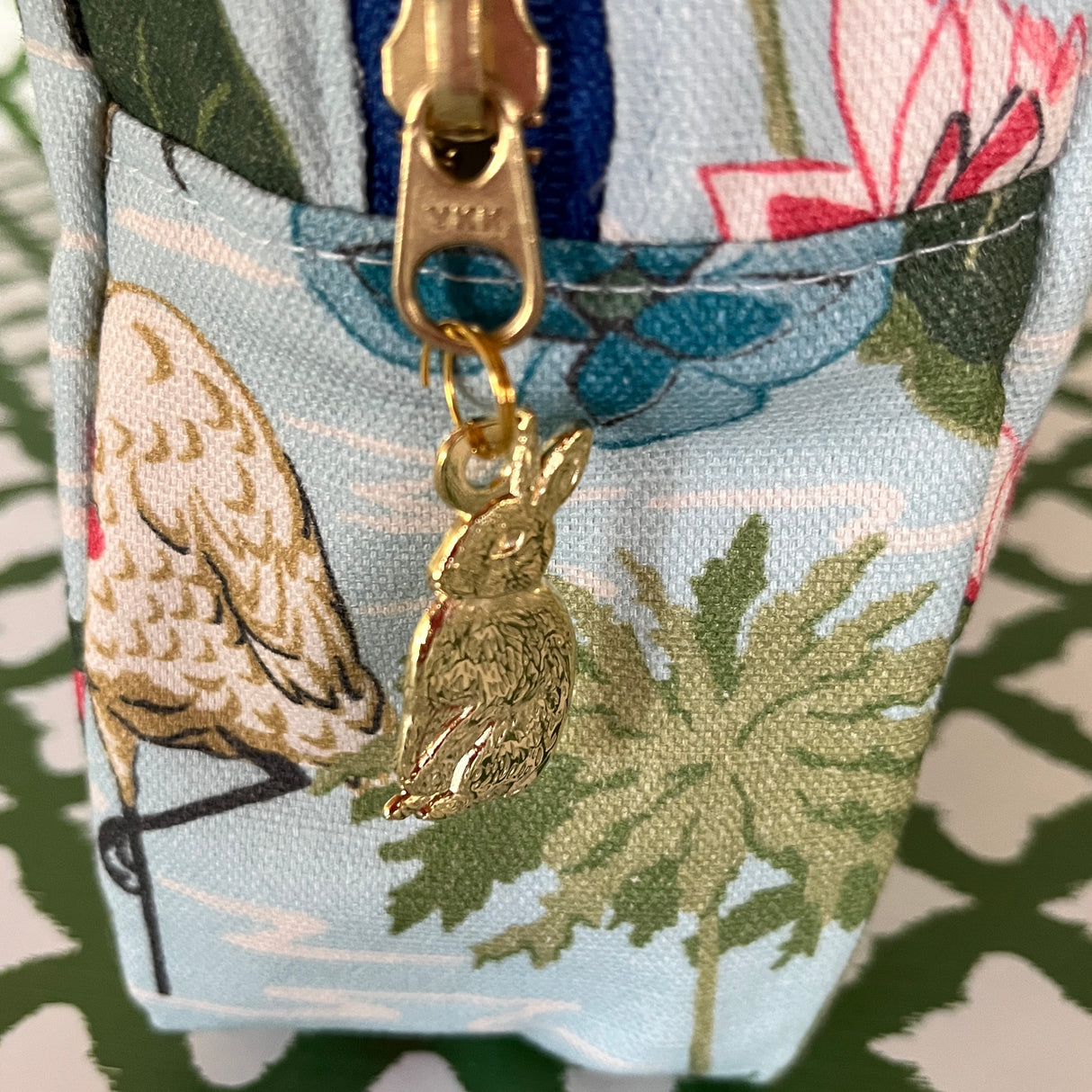 Meadow Club toiletry bag in sky blue features a lily pond pattern showing pull detail