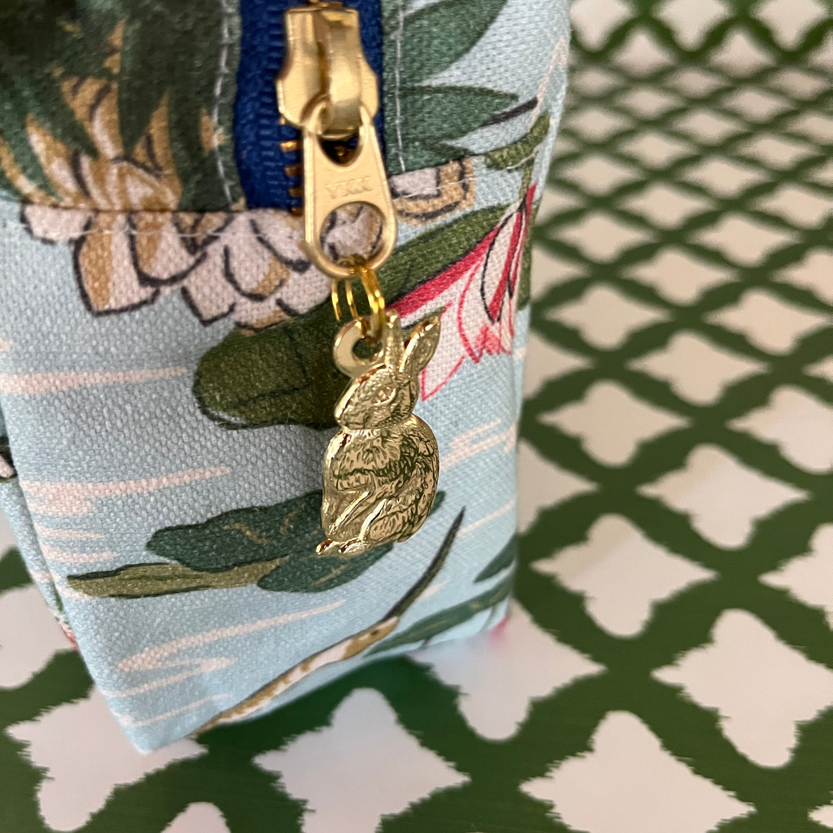 Pull detail of Meadow Club toiletry bag in sky blue features a lily pond pattern