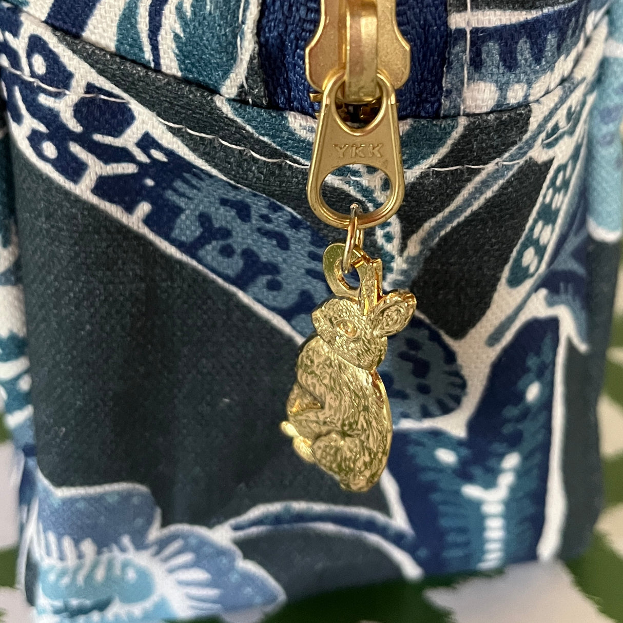 Pull detail for Temple Garden toiletry bag in navy blue features light blue floral motif.