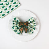 green rattan bow napkin ring on napkin on white plate