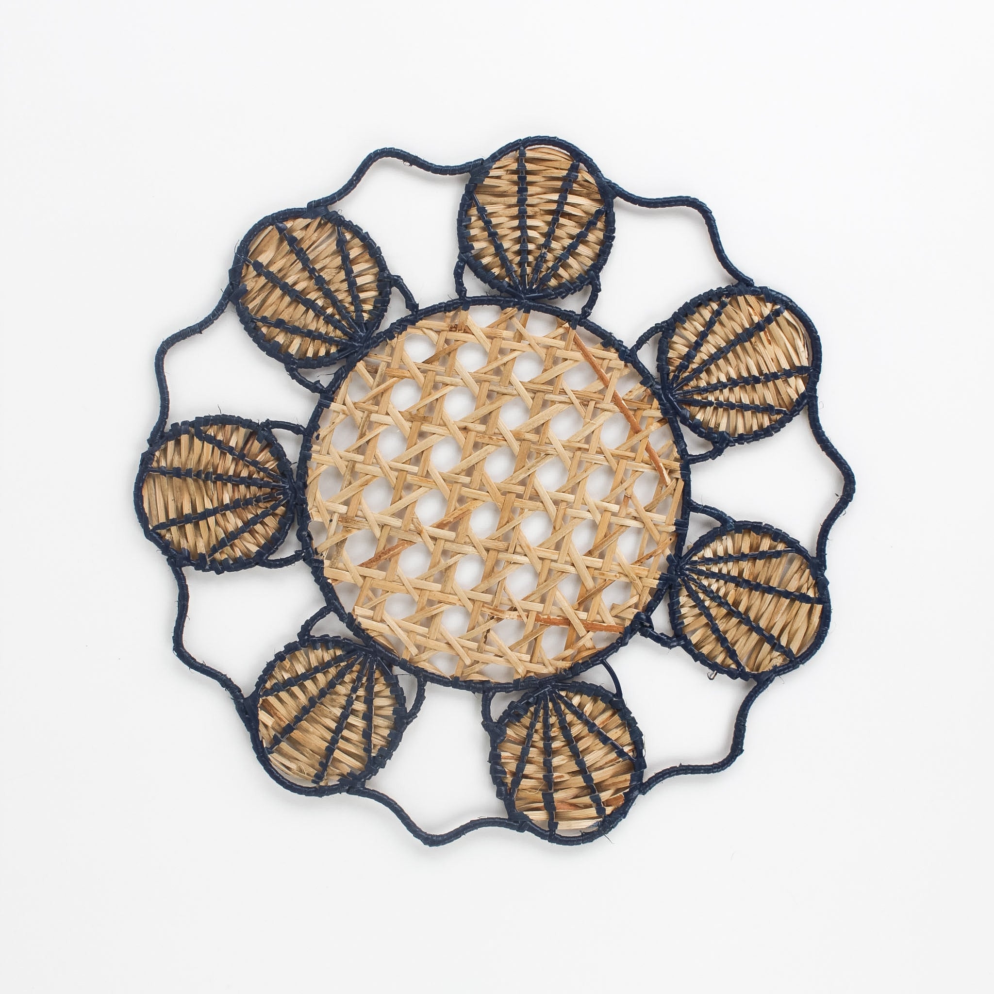 Decorative woven rattan placemat with shell patterns on a white background