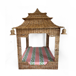a rattan pagoda dog bed with a green pink and white striped mattress from madcap cottage