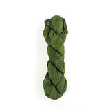 a recycled torn-silk ribbon in green laid in a white surface