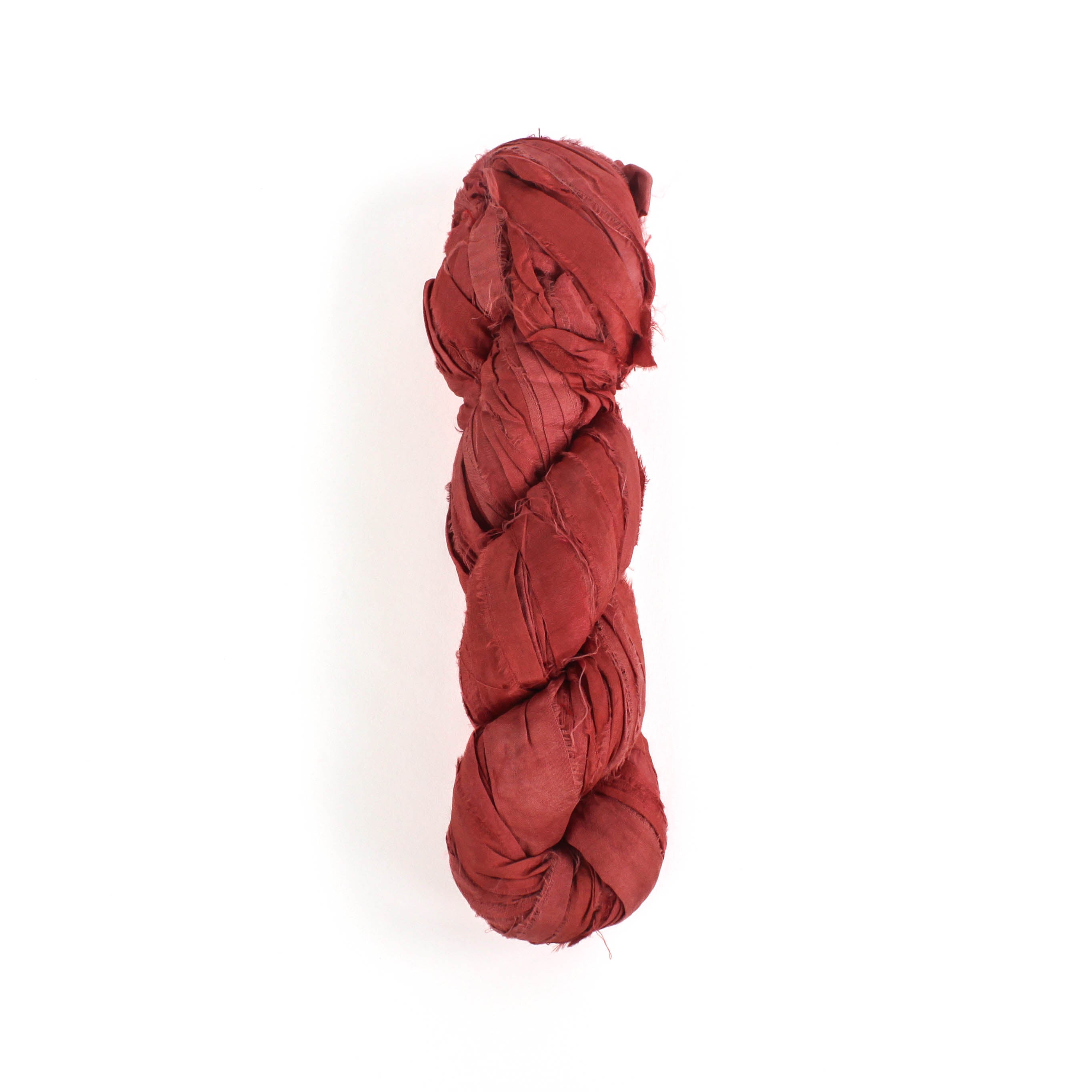 a recycled torn-silk ribbon in pink laid in a white surface