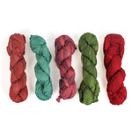 5 sets of recycled torn-silk ribbon in different colors laid in a white surface