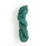 a recycled torn-silk ribbon in aqua laid in a white surface