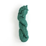 a recycled torn-silk ribbon in aqua laid in a white surface