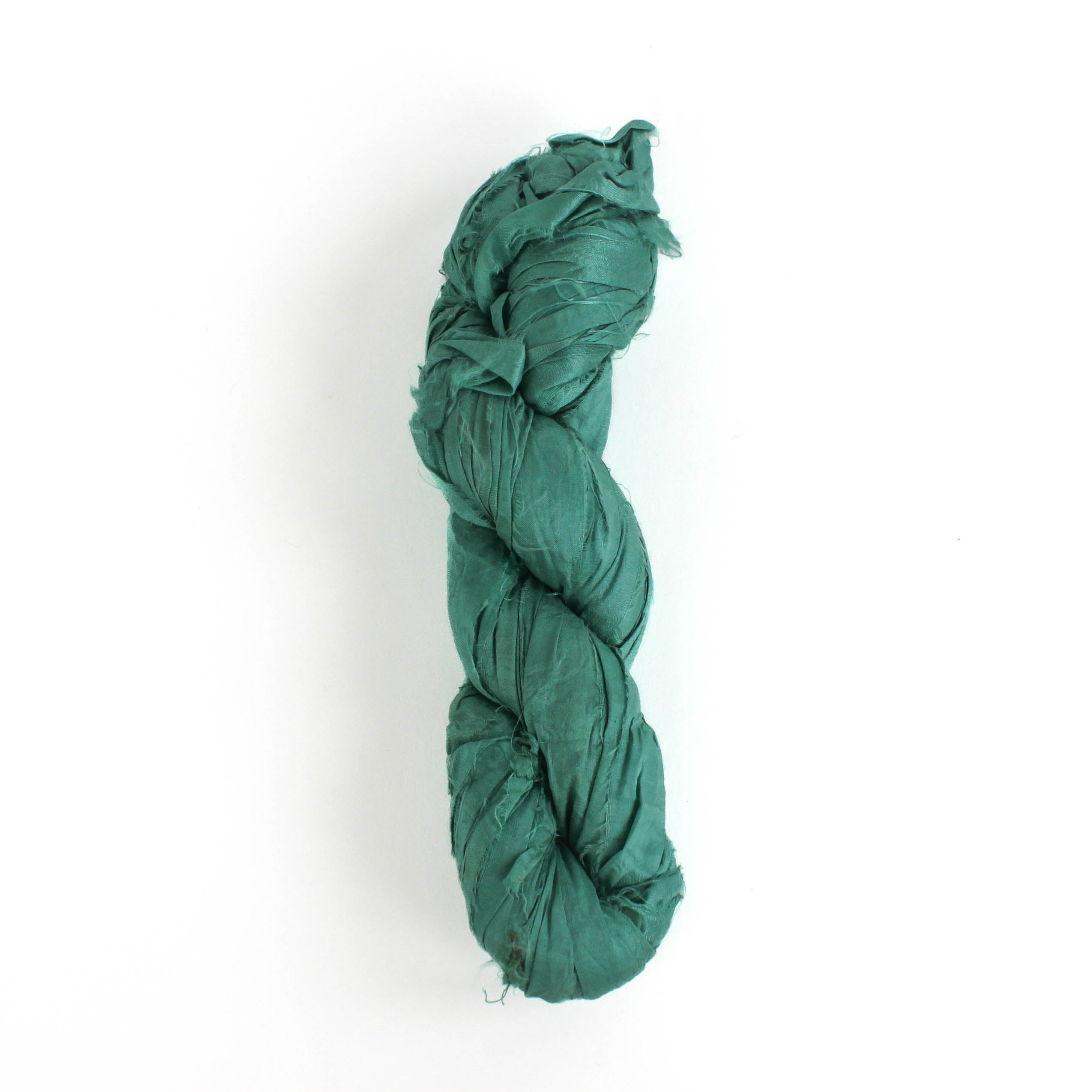 a recycled torn-silk ribbon in aqua laid in a white surface
