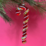 red glass candy cane ornaments on a pink background