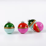 Four colorful Christmas ornaments with gold bands on a white background