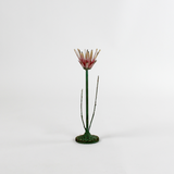 a large metal flower candle holder in the shape of a red lotus on a white background