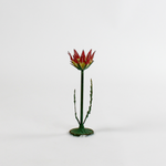 a small metal flower candle holder in the shape of a red lotus on a white background