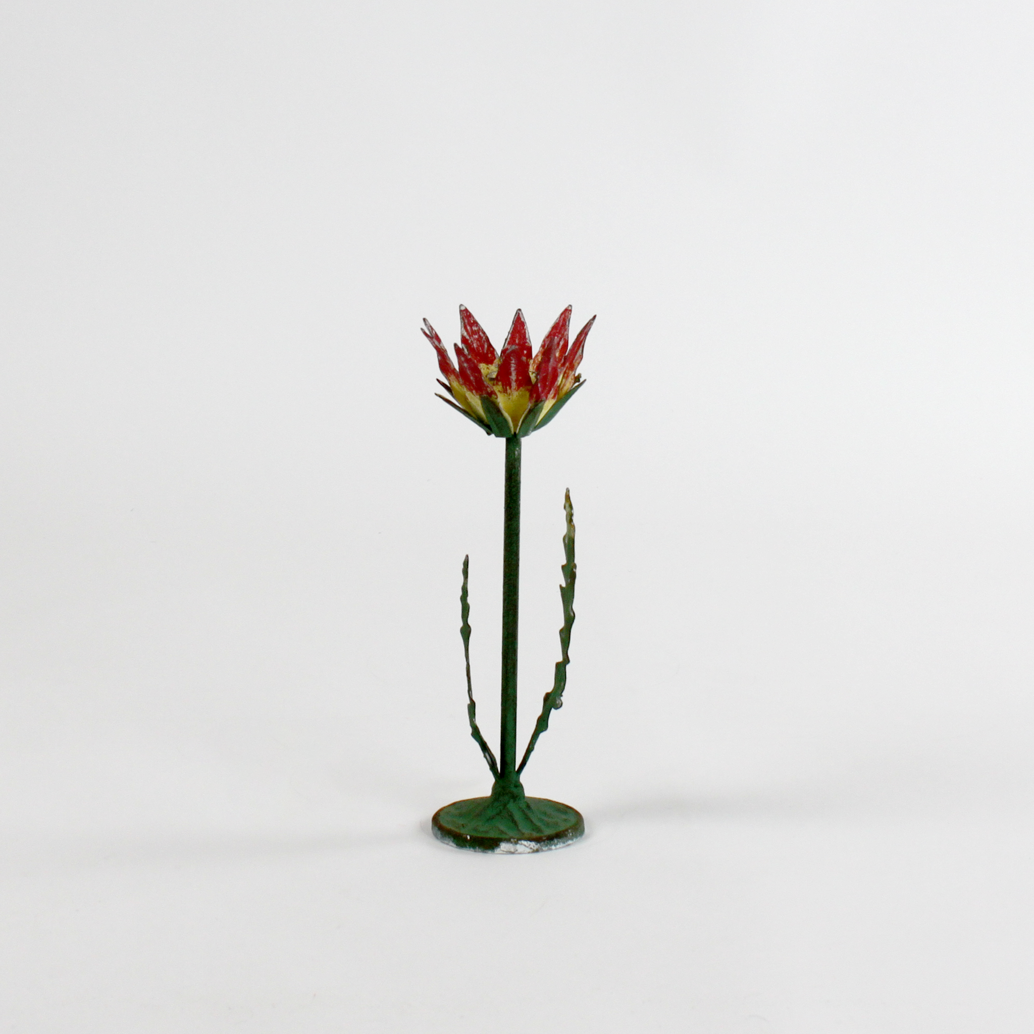 a small metal flower candle holder in the shape of a red lotus on a white background