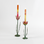 Two decorative metal Red Lotus flower sculptures with colorful candles on a white background
