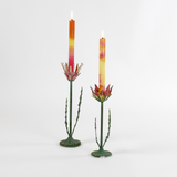 Two decorative metal Red Lotus flower sculptures with colorful candles on a white background