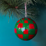 green red checkered christmas ornaments on a blue background