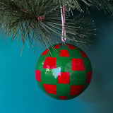 green red checkered christmas ornaments on a blue background