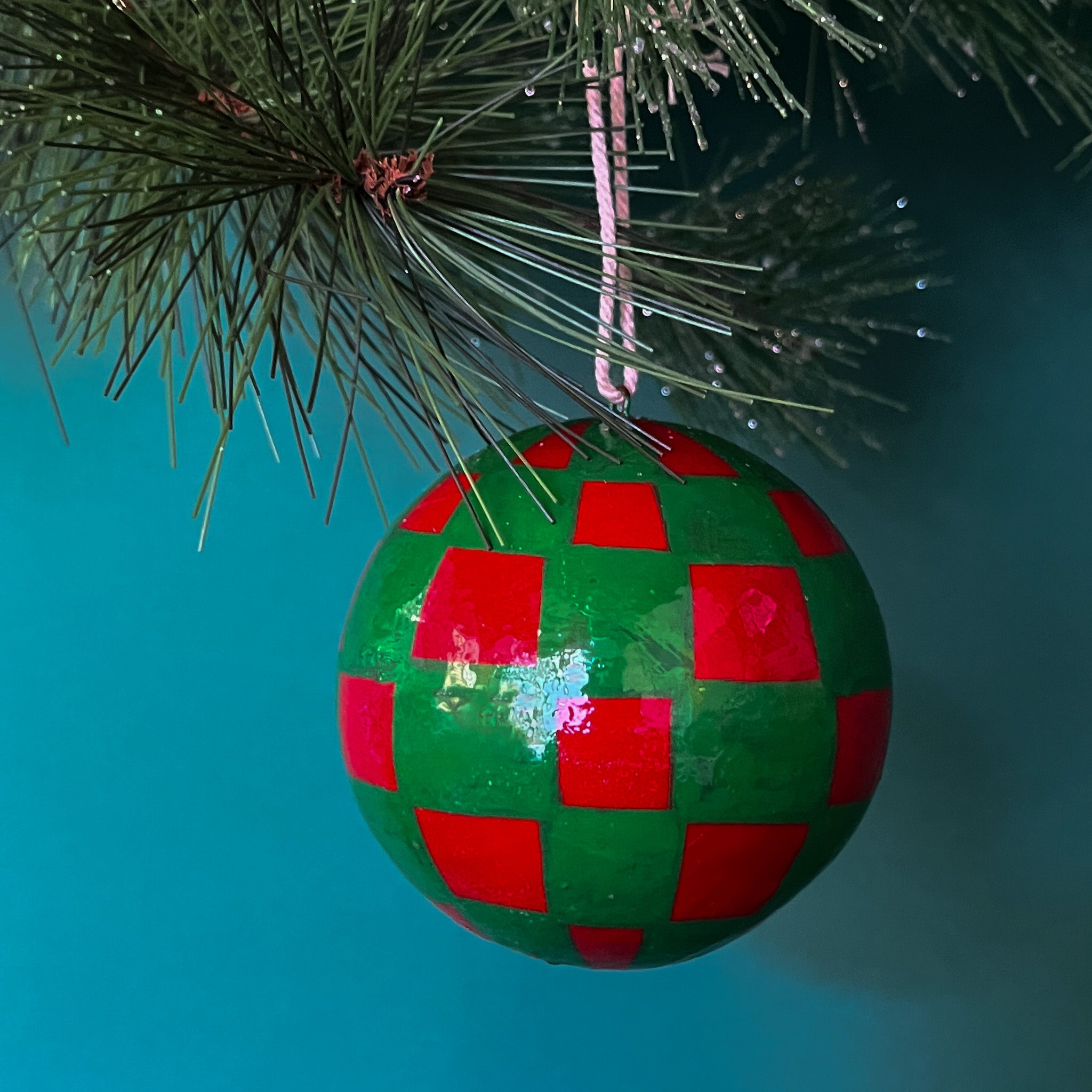 green red checkered christmas ornaments on a blue background