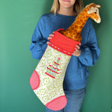 a Red and green chinoiserie Christmas stocking with a pagoda design held by a lady