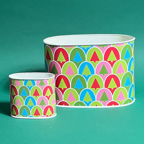 Two cylindrical caddy containers with a Christmas-themed pattern featuring geometric trees in red, green, blue, pink and white colors.