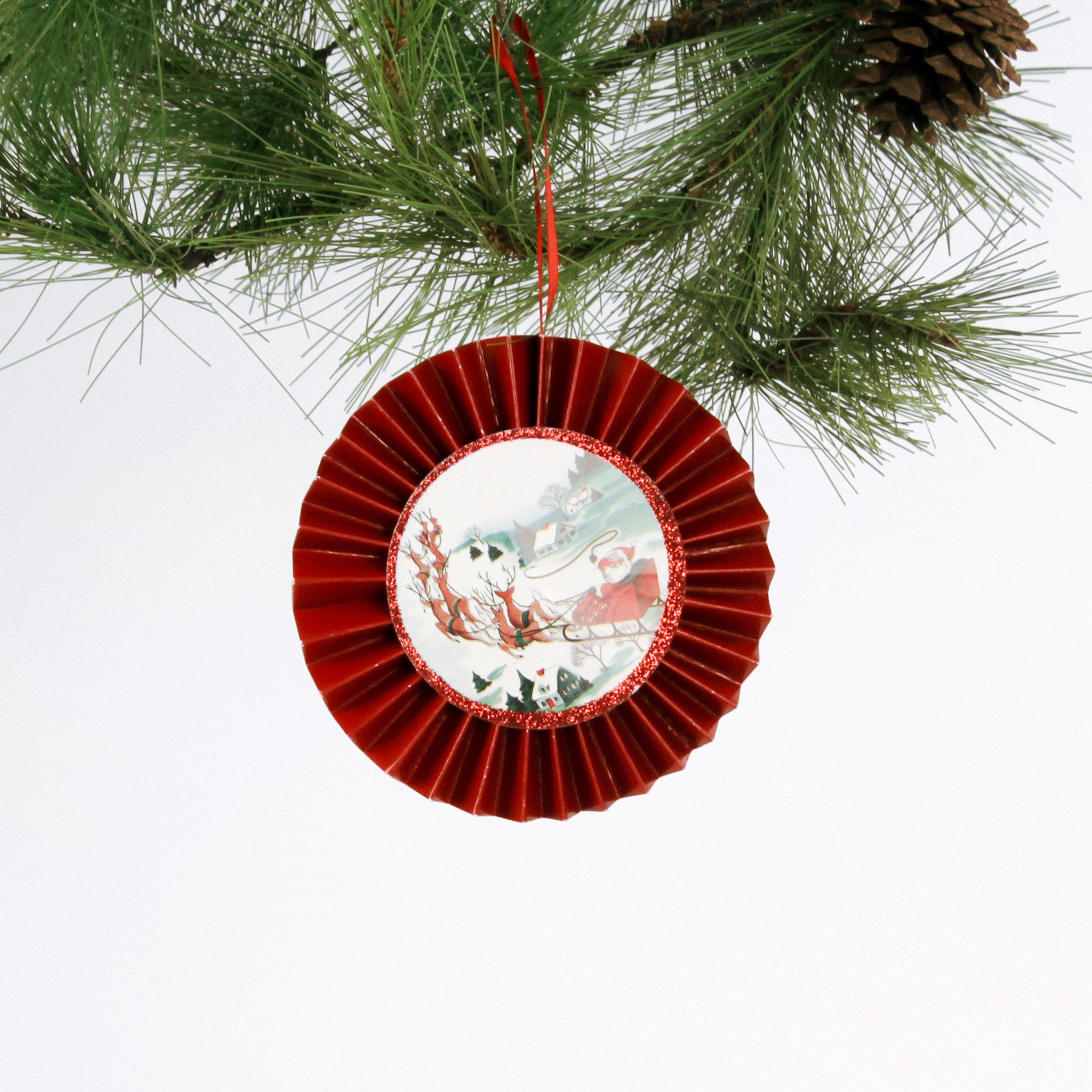 retro-style ruffled paper Christmas ornaments featuring vintage illustration, accented with red pleated borders and hanging ribbons