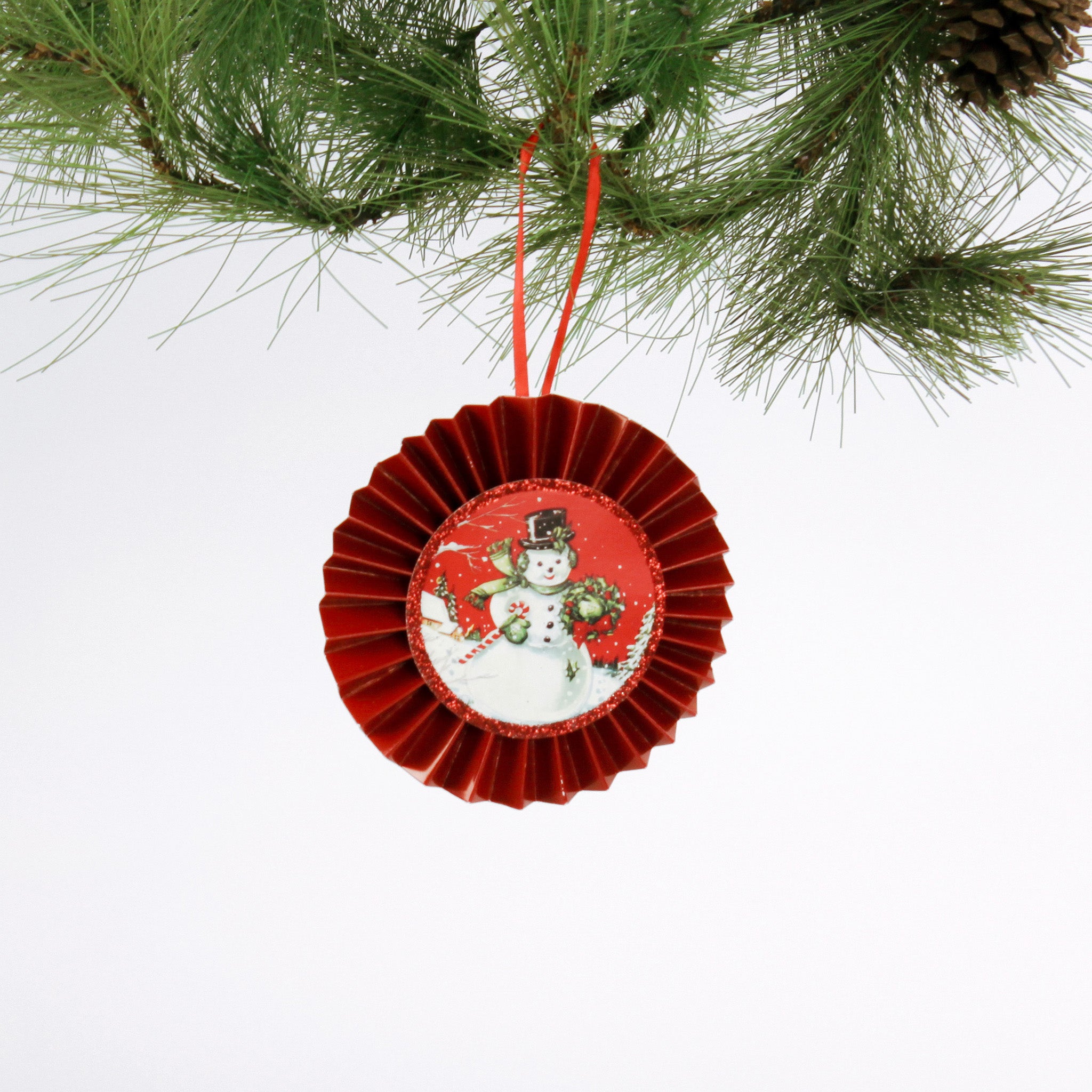 retro-style ruffled paper Christmas ornaments featuring vintage illustration, accented with red pleated borders and hanging ribbons