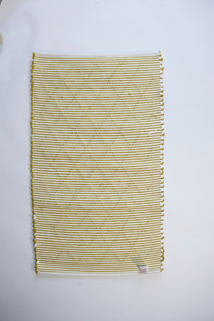the reverse side of a recycled cotton yellow accent rug with a repeating diamond motif from Madcap Cottage. 