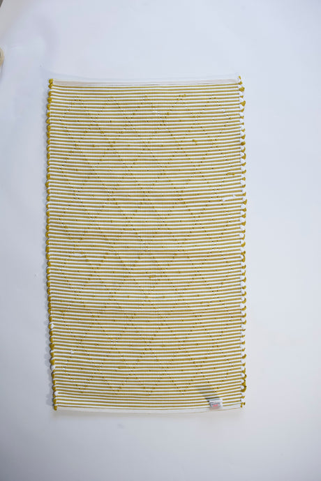 the reverse side of a recycled cotton yellow accent rug with a repeating diamond motif from Madcap Cottage. 