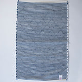 the reverse side of a cotton blue accent rug with a repeating diamond motif from Madcap Cottage. 
