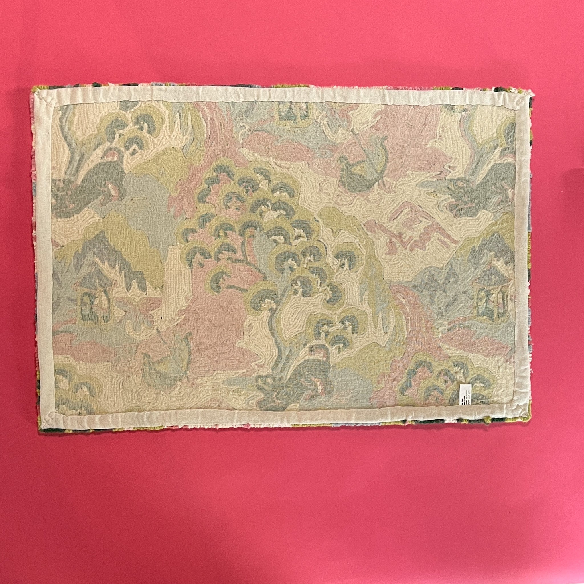 Reverse side of a pink green and blue rug with chinoiserie motifs