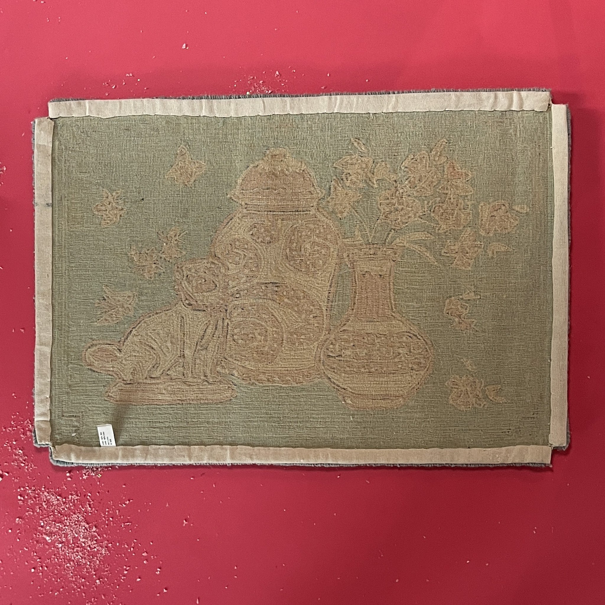reverse of A small pink and green rug with chinoiserie motifs.