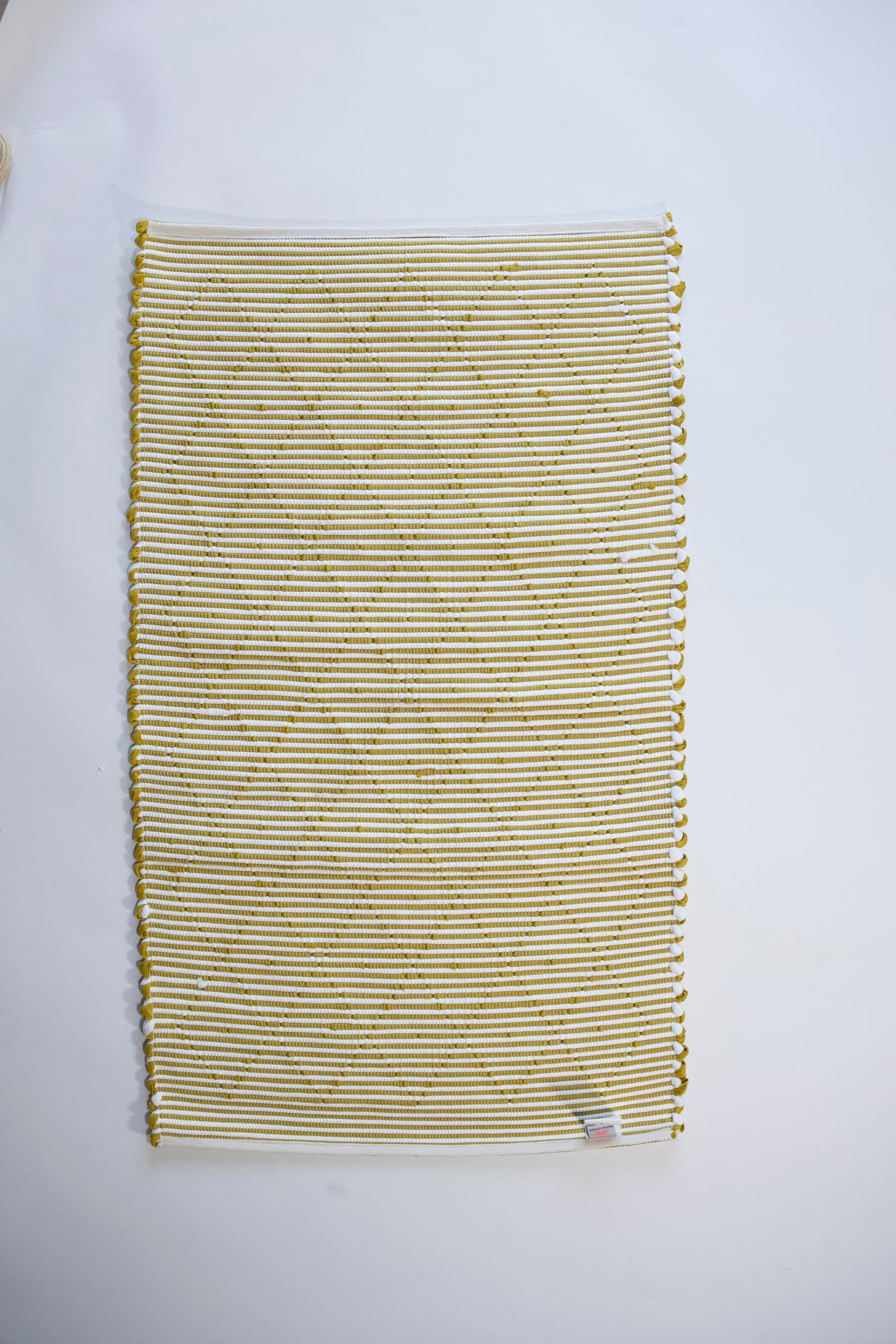 the reverse side of A cotton blue accent rug with a repeating diamond motif from Madcap Cottage. 