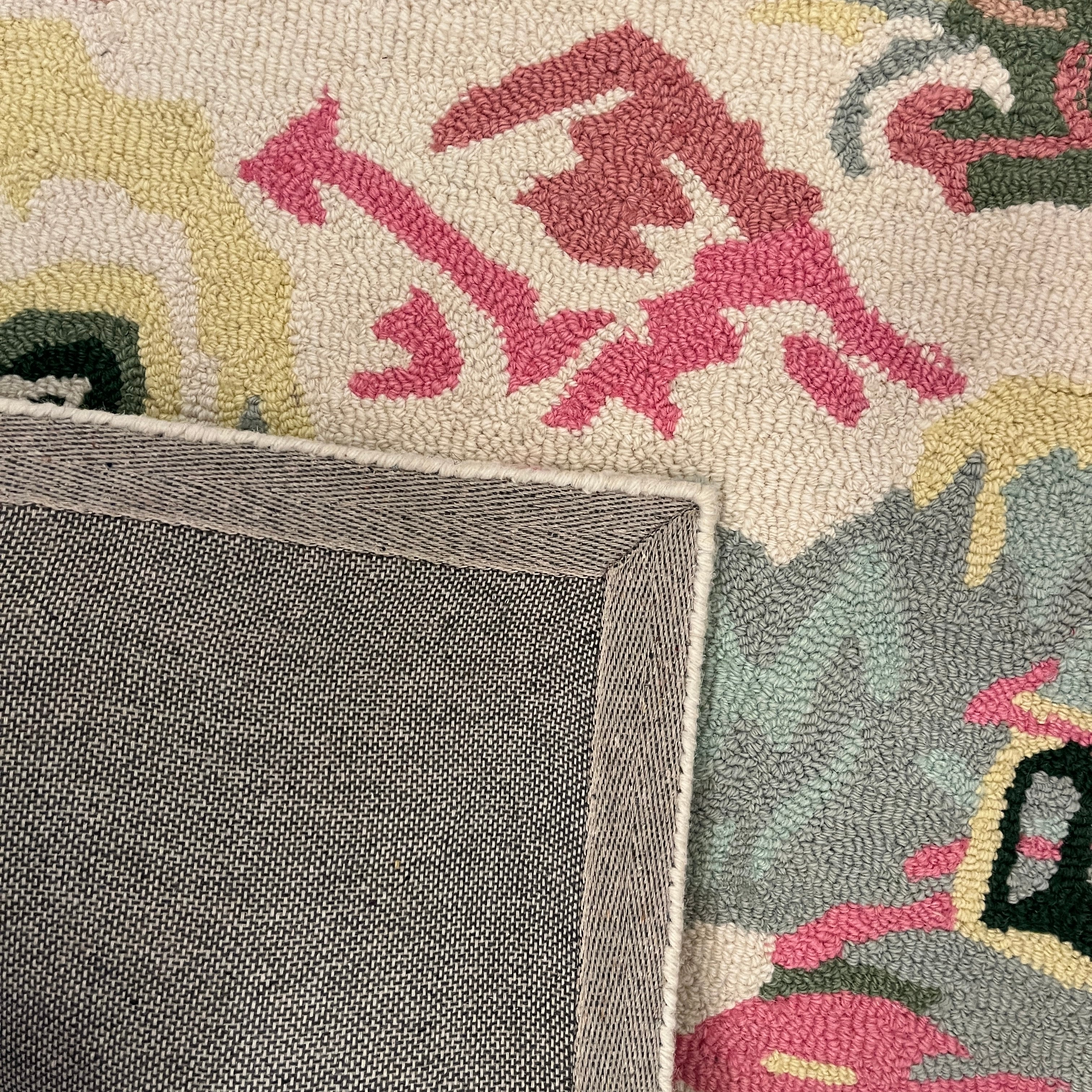 the reverse side a of an Old Peking pink and green rug with chinoiserie motifs from madcap cottage