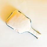 Reverse side of a paddle shaped pickeball pillow featuring blue and white stripes and text that reads "Pickle Ball Club"