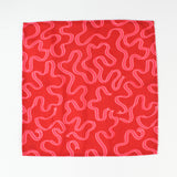 Red and pink ribbon-print Christmas tea towel napkin folded to show inside lining, made in USA fabric