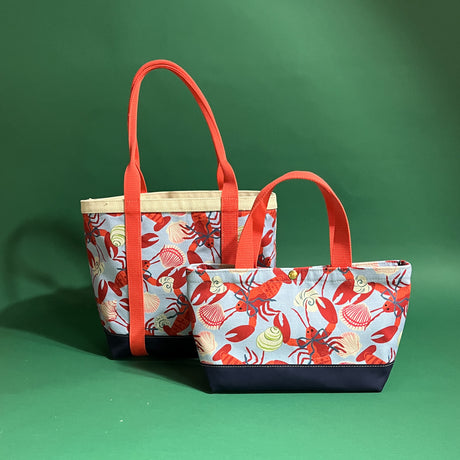 Two Rock Lobster canvas tote bags with a lobster pattern, one large and one small, against a green background.