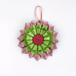 ruffled paper Christmas ornaments in shimmering green and purple glitter with red centers