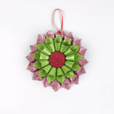 ruffled paper Christmas ornaments in shimmering green and purple glitter with red centers