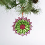 ruffled paper Christmas ornaments in shimmering green and purple glitter with red centers