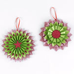 Set of two ruffled paper Christmas ornaments in shimmering green and purple glitter with red centers