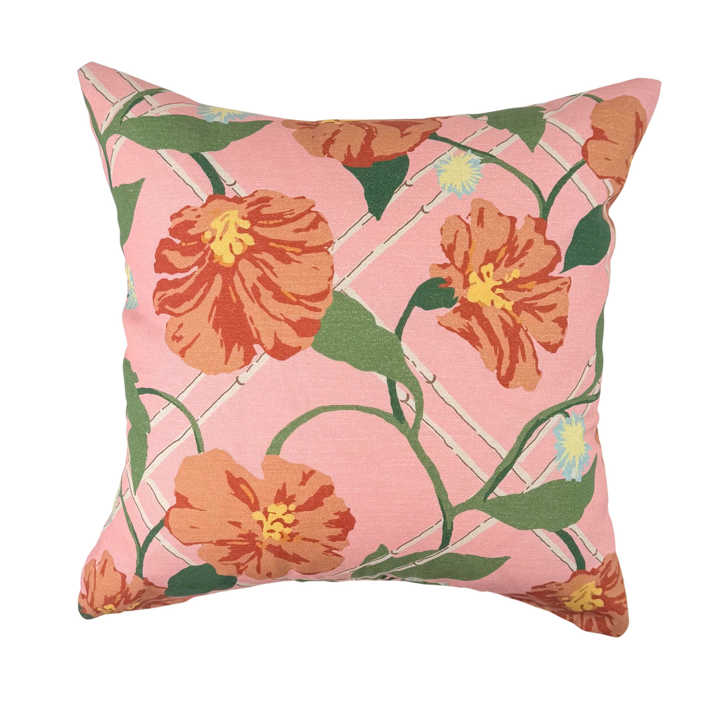 Pink tropical outdoor pillow with vibrant orange floral accents.